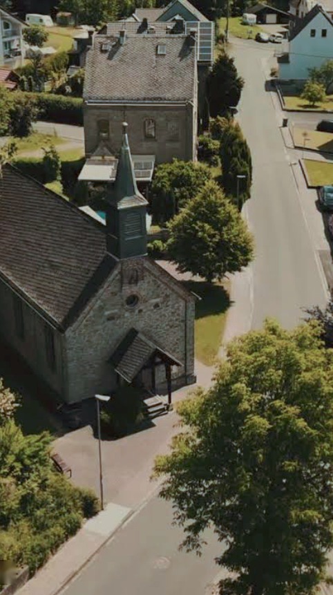Luftbild: Kapelle und altes Schulhaus nebeneinander an der Hauptstraße